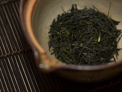 Gros plan sur des feuilles de Sencha séchées prêtes à infuser.