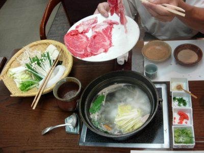 Tranches de bœuf fines plongées dans un bouillon de Shabu Shabu