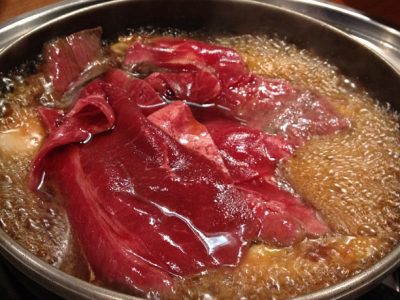 Zoom sur des tranches de bœuf dans un bouillon de sukiyaki