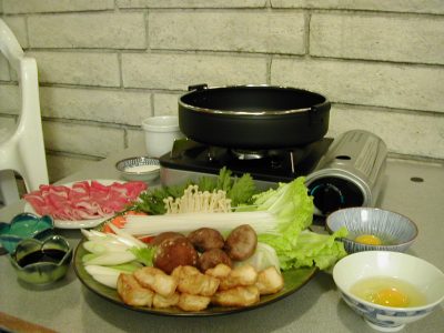 Ingrédients du sukiyaki disposés autour d’une marmite japonaise