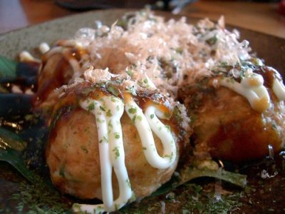 Assiette de takoyaki nappés de sauce et de katsuobushi